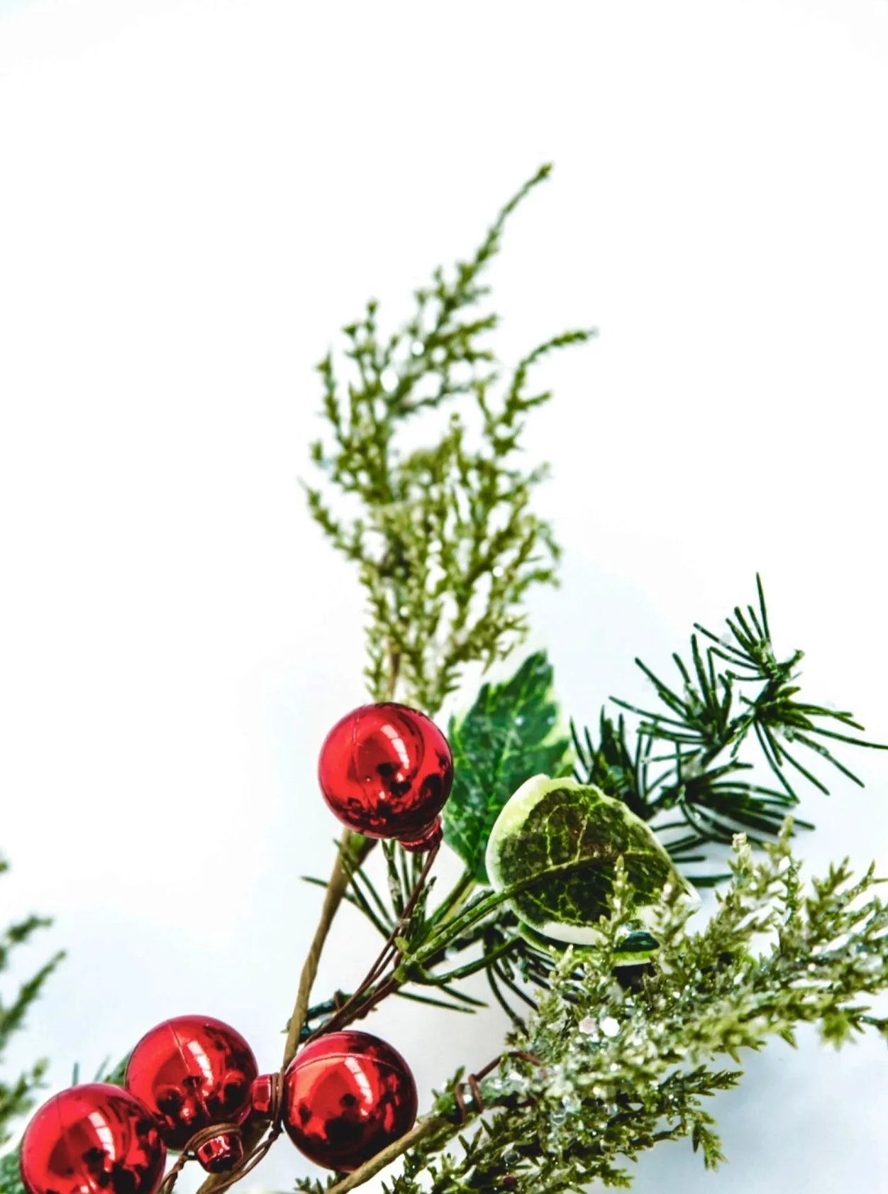 Cedar and holly spray with red ornaments