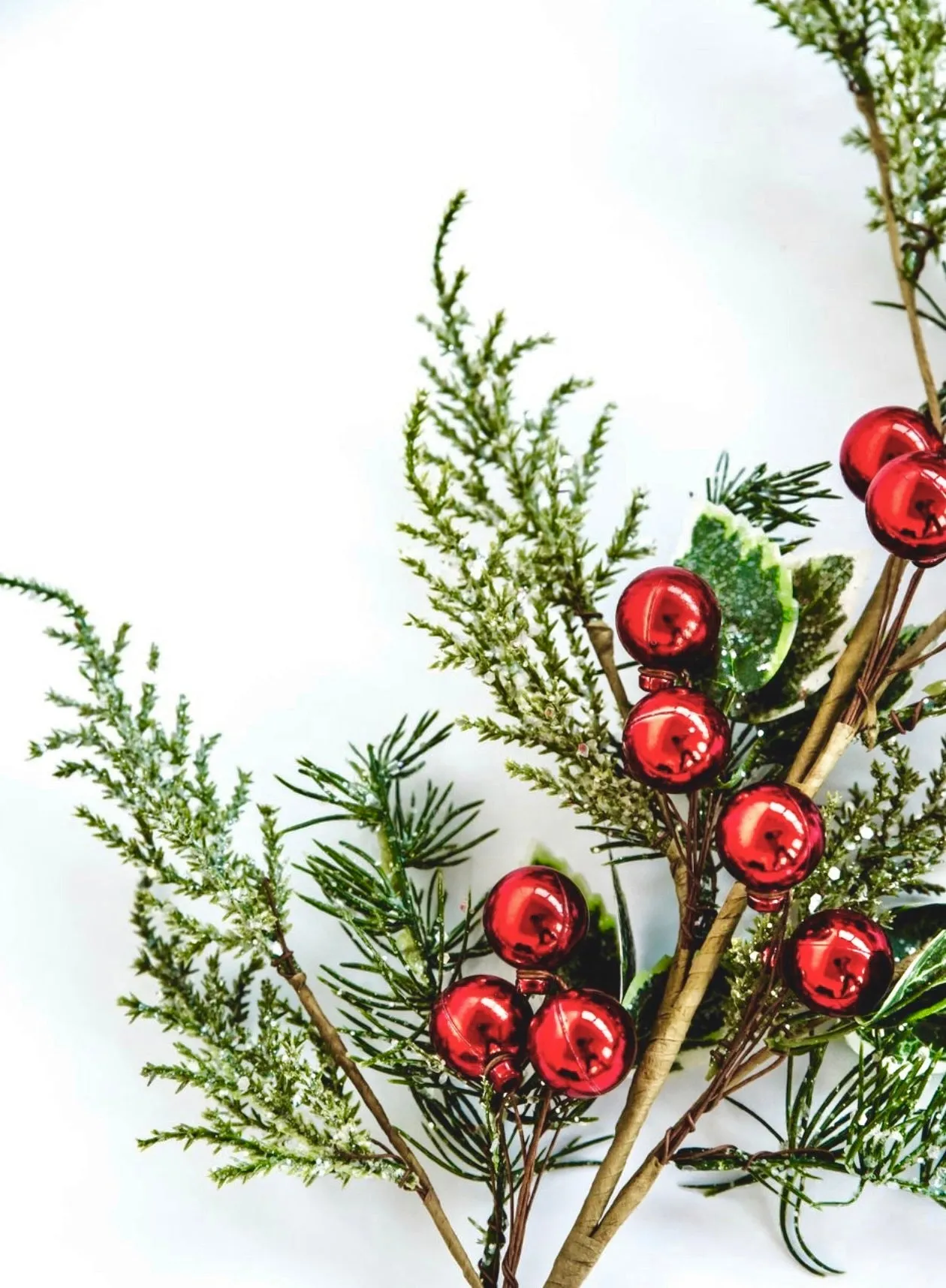 Cedar and holly spray with red ornaments